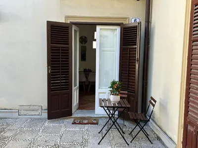 a door to a building with a table and a plant at Corte dei Re di Palermo Apartment in Palermo
