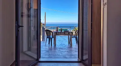 an open door to a balcony with a table and chairs at VISTA MARE in Alcamo Marina