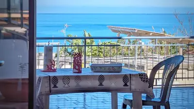 a table on a balcony with a view of the ocean at VISTA MARE in Alcamo Marina