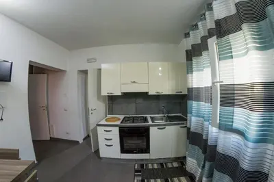 a kitchen with white cabinets and a stove top oven at Villa Giambona in Isola delle Femmine