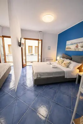 a bedroom with a bed and a blue wall at Oikos Design Sicily in Castellammare del Golfo