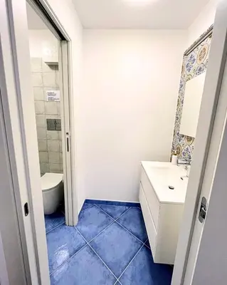 a bathroom with a white sink and a toilet at Oikos Design Sicily in Castellammare del Golfo