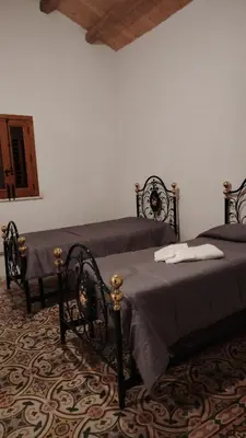 a bedroom with two beds and a table at casa di campagna iobio in Alcamo