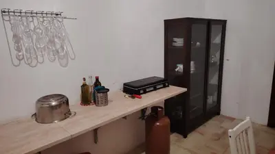 a kitchen with a counter and a cabinet with utensils at casa di campagna iobio in Alcamo