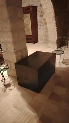 a large black table in a room with two chairs at casa di campagna iobio in Alcamo