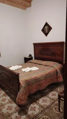 a bedroom with a wooden bed with towels on it at casa di campagna iobio in Alcamo