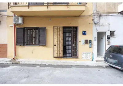 a building with a door and a car parked in front at Case Billeci Casa Verde in Palermo