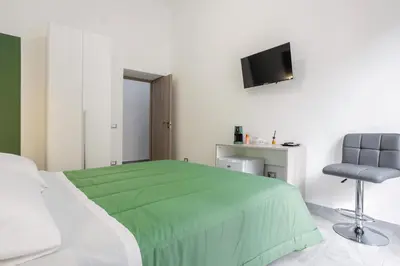 a bedroom with a green bed and a chair at Case Billeci Casa Verde in Palermo