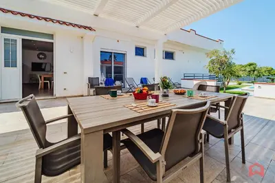 a wooden table and chairs on a patio at Villa con Piscina sul Mare a Terrasini in Terrasini