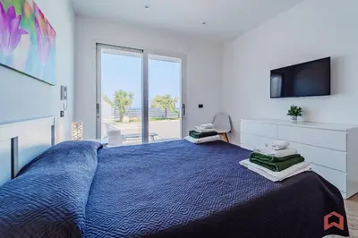 a bedroom with a blue bed and a tv at Villa con Piscina sul Mare a Terrasini in Terrasini