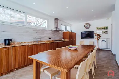 a kitchen with a wooden table and a dining room at Villa con Piscina sul Mare a Terrasini in Terrasini