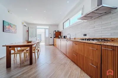 a kitchen with wooden cabinets and a wooden table at Villa con Piscina sul Mare a Terrasini in Terrasini
