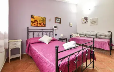 two beds in a bedroom with pink sheets at 4 Bedroom Stunning Home In Trappeto in Trappeto