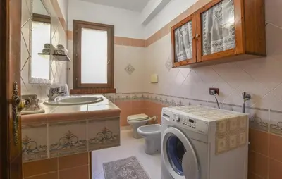 a bathroom with a washing machine and a toilet at 4 Bedroom Stunning Home In Trappeto in Trappeto