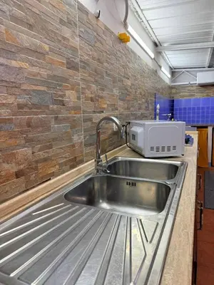 a stainless steel sink in a kitchen with a brick wall at Casa Julia in Palermo