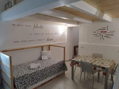 a room with a bed and a table with chairs at Casa Veni Ka in Palermo