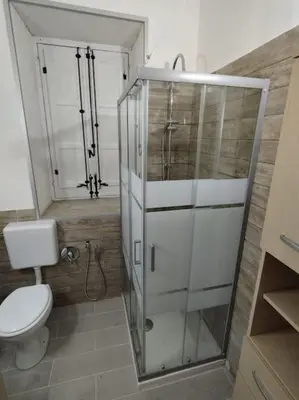a bathroom with a toilet and a glass shower at Casa Veni Ka in Palermo