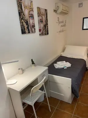 a small room with a desk and a bed at Petit Maison in Palermo