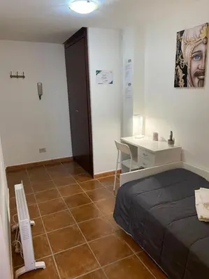 a bedroom with a bed and a desk and a table at Petit Maison in Palermo