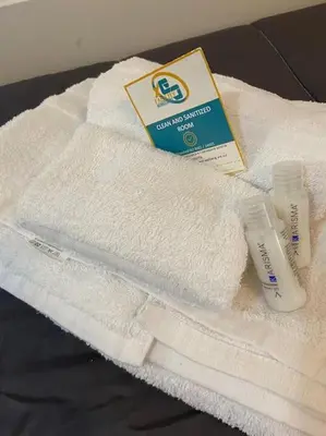 a pile of white towels with a bottle of toothpaste at Petit Maison in Palermo