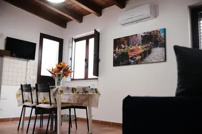 a dining room with a table with chairs and a vase of flowers at Al bastione della pace in Palermo