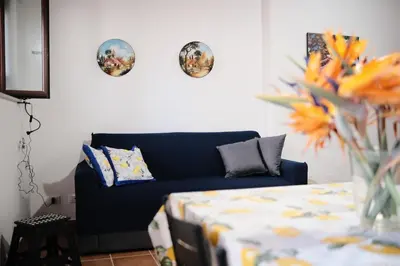 a living room with a blue couch and plates on the wall at Al bastione della pace in Palermo