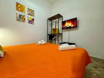 a bedroom with an orange bed with towels on it at La Dimora di Anna e Ciccio in Casteldaccia