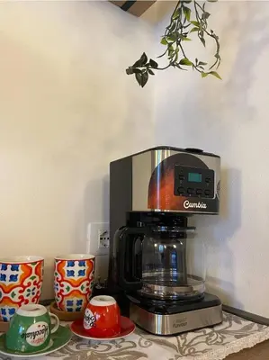 a coffee maker sitting on top of a table with cups at La Barbera's apatments old town PA in Palermo