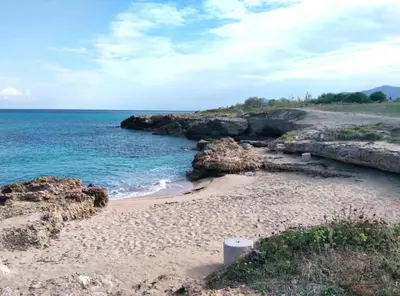 a sandy beach with the ocean and rocks at Casita Garden&Spa in Carini
