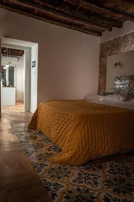 a bedroom with a bed with an orange blanket on it at Casa Verderame in Palermo