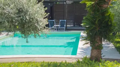 a swimming pool with two chairs and a palm tree at Casa Gelsomino POOL&SEAVIEW in Palermo