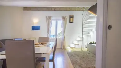 a living room with a dining room table and a staircase at Casa Gelsomino POOL&SEAVIEW in Palermo