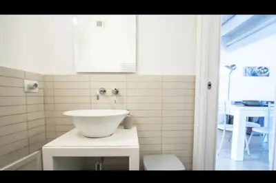 a bathroom with a white sink and a table at Casa Gelsomino POOL&SEAVIEW in Palermo