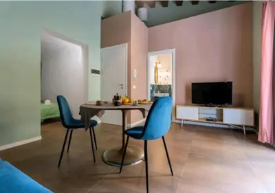 a living room with a table and chairs and a television at Appartamenti Franco il Conte in Bagheria