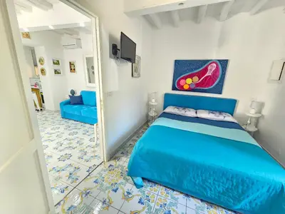 a bedroom with a blue bed and a mirror at SUITE AND RELAX TINA a 2 passi dal centro e al foro italico in Palermo