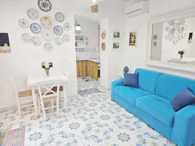 a living room with a blue couch and a table at SUITE AND RELAX TINA a 2 passi dal centro e al foro italico in Palermo