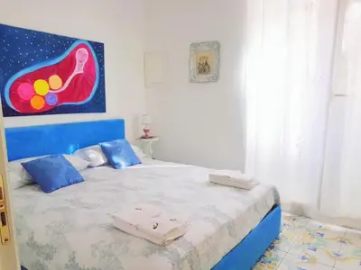 a bedroom with a bed with a painting on the wall at SUITE AND RELAX TINA a 2 passi dal centro e al foro italico in Palermo