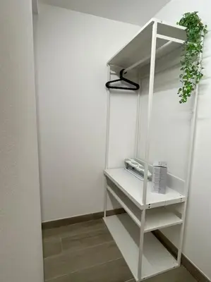 a white shelf with a plant on top of it at MaRó Loft al Capo in Palermo