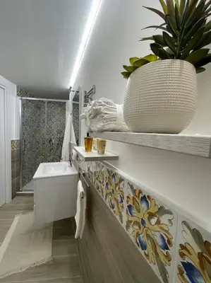 a bathroom with a sink and a potted plant at MaRó Loft al Capo in Palermo