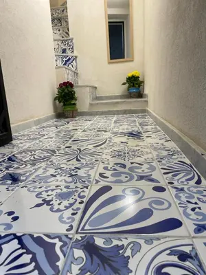 a hallway with a blue and white tile floor at MaRó Loft al Capo in Palermo