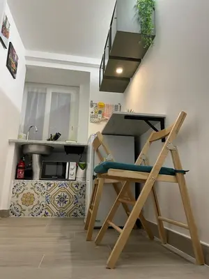 a kitchen with a wooden chair in front of a sink at MaRó Loft al Capo in Palermo