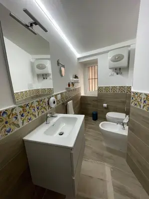 a bathroom with a sink and a toilet and a mirror at MaRó Loft al Capo in Palermo