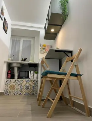 a kitchen with a wooden chair in front of a sink at MaRó Loft al Capo in Palermo