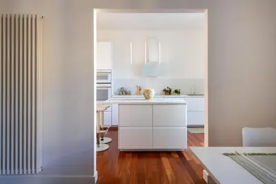a white kitchen with white cabinets and a table at Casa Madà vicino al Politeama by Wonderful Italy in Palermo