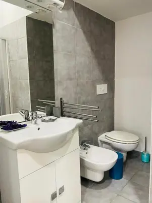 a bathroom with a white sink and a toilet at Maqueda Vibes in Palermo