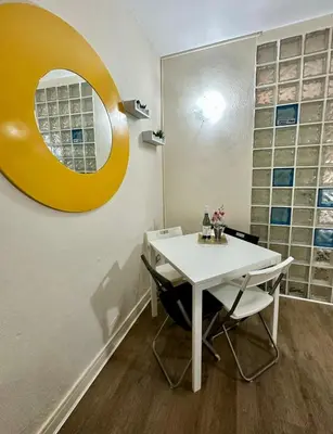 a dining room with a white table and a mirror at Merlino Smarthouse alla Zisa in Palermo