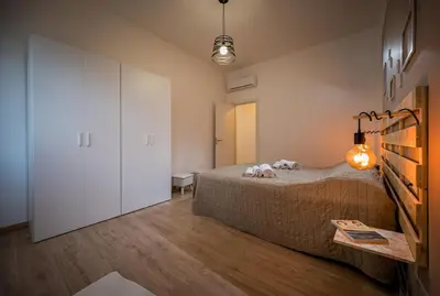 a bedroom with a bed and a white closet at Casa vacanza la finestra sul porto in Castellammare del Golfo