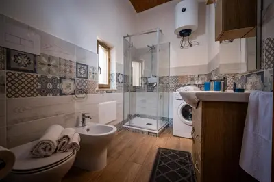 a bathroom with a toilet sink and a washing machine at Casa vacanza la finestra sul porto in Castellammare del Golfo