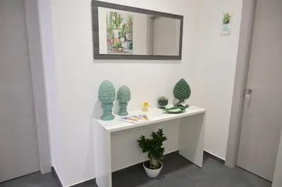 a white table with vases and a mirror on a wall at Da 'Nfacci Affittacamere in Carini