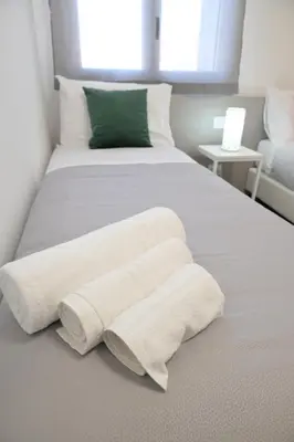 a white bed with two white towels on it at Da 'Nfacci Affittacamere in Carini